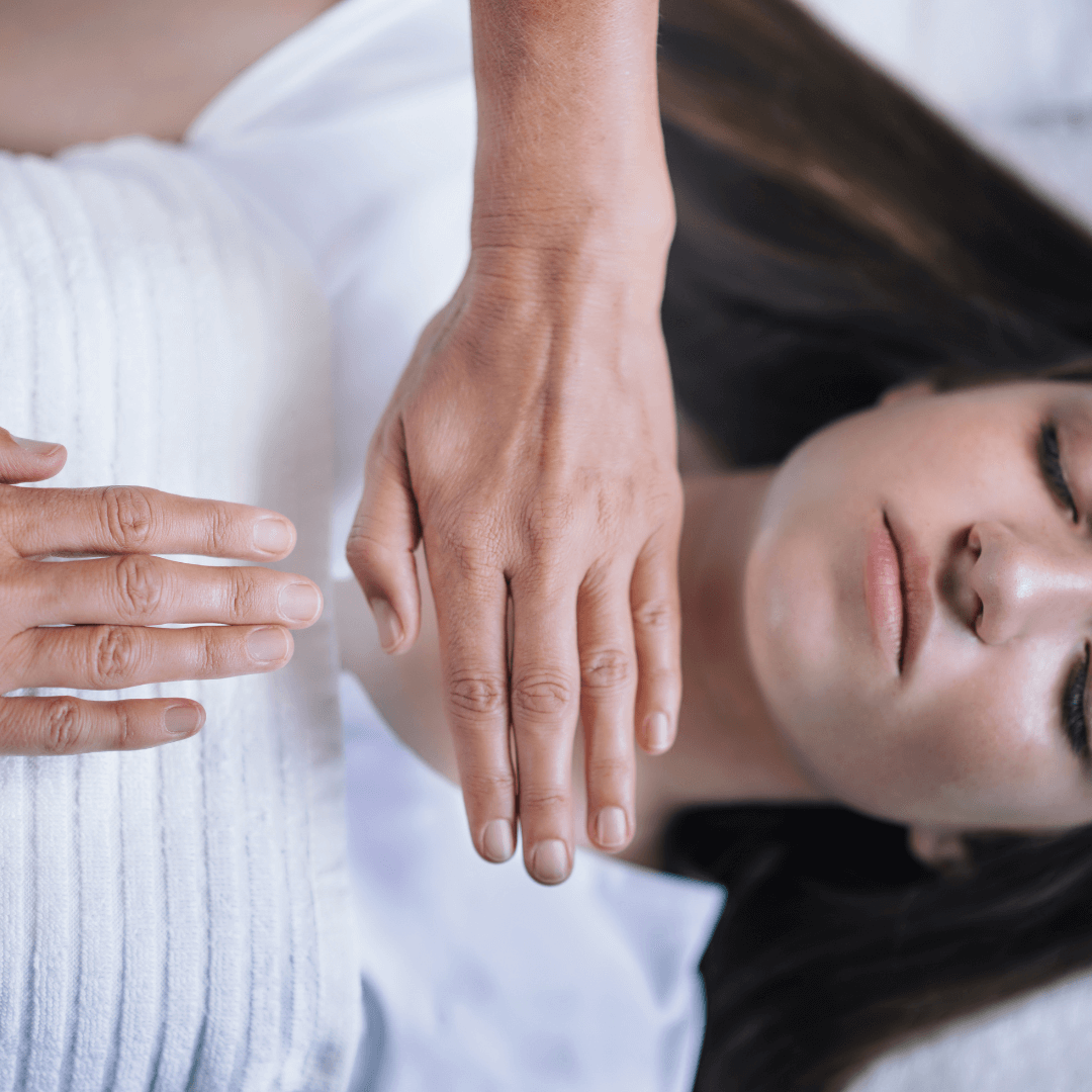Séance de Reiki à Chavornay Un praticien de Reiki plaçant ses mains au-dessus d'un patient allongé, illustrant une séance de soins énergétiques Reiki à Chavornay.