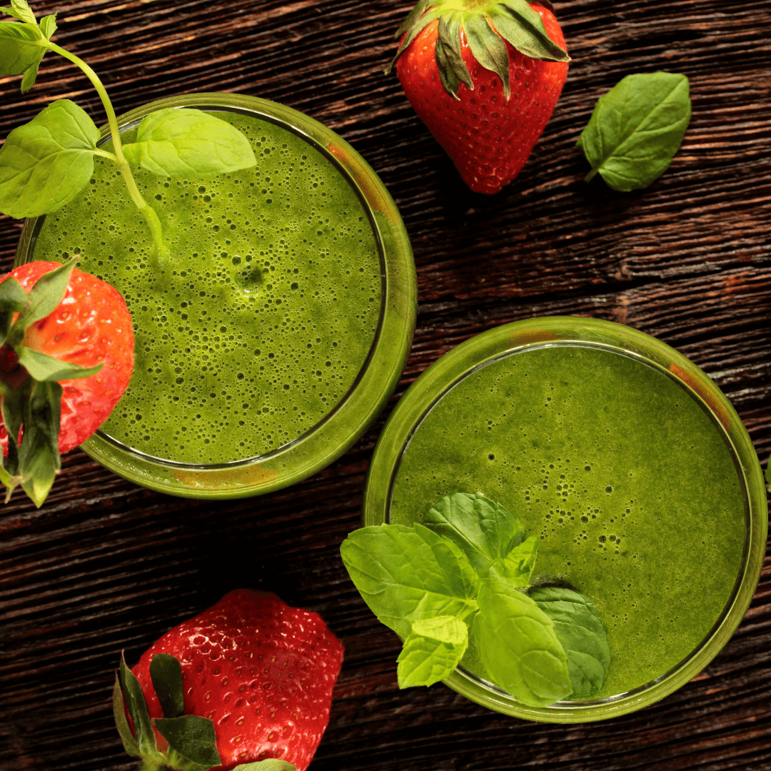 Conseils en nutrition à Cossonay Deux verres de smoothie vert garnis de feuilles de menthe fraîche, accompagnés de fraises, illustrant les services de conseils en nutrition disponibles à Cossonay.